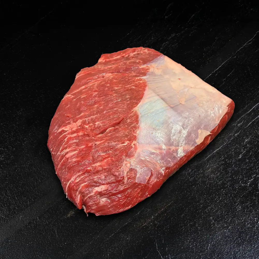 Ein Stück Tafelspitz oder Picanha liegt auf dunklem Hintergrund.