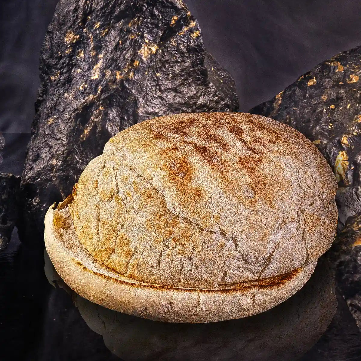 Ein aufgeschnittenes Burger-Bun Brötchen vor Steinhintergrund