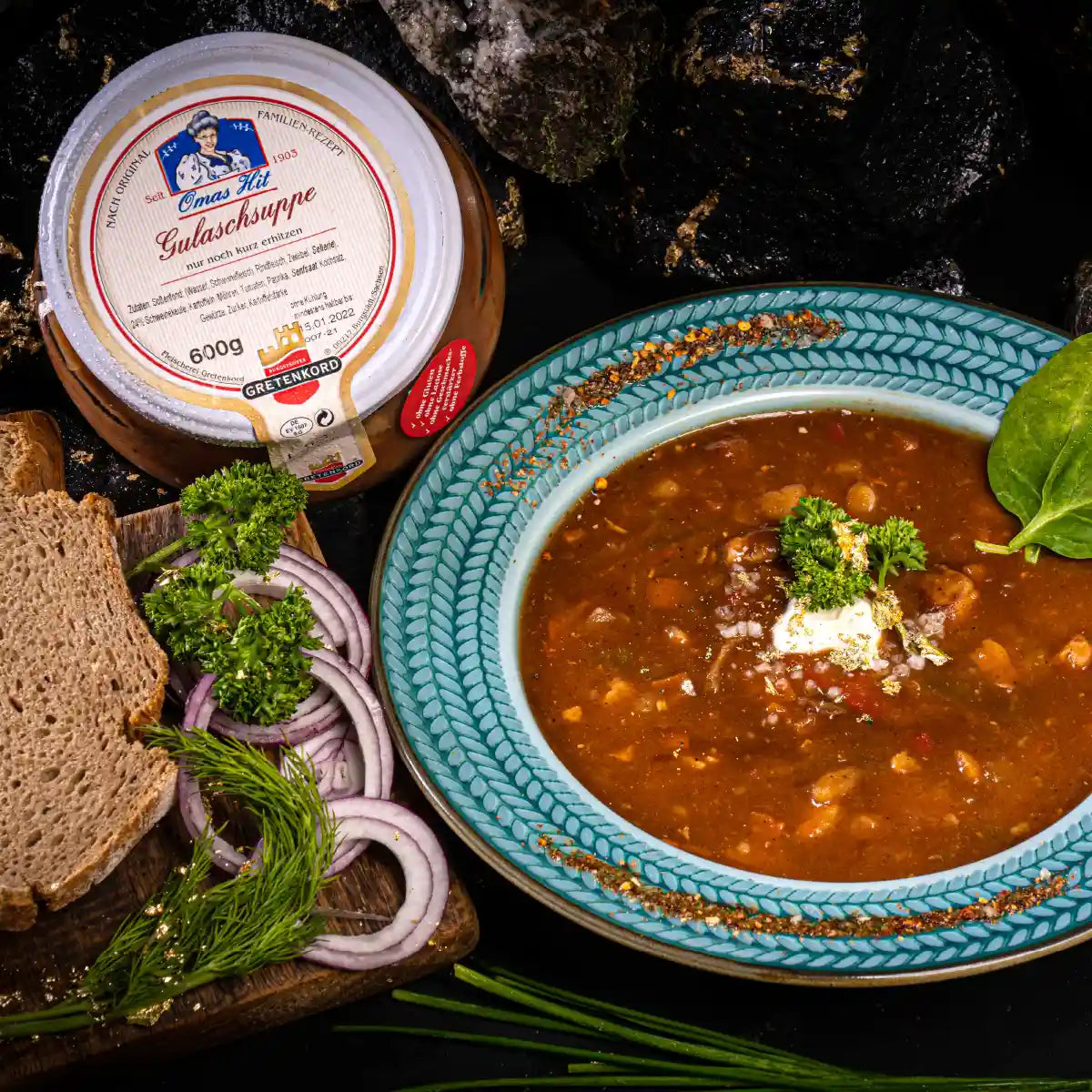 Gulaschsuppe im Teller neben Glas