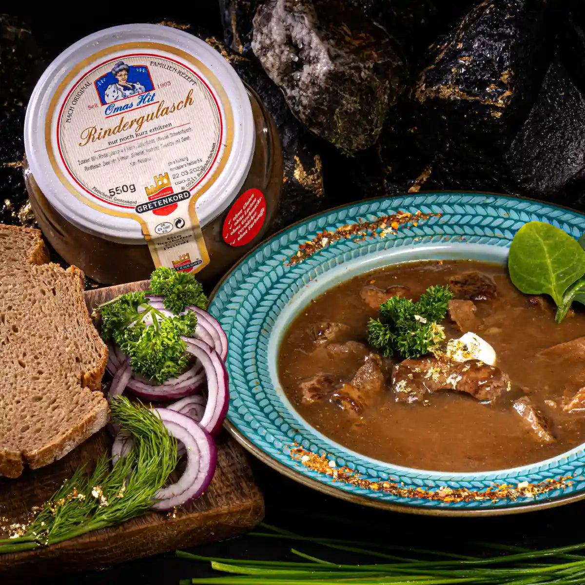 Rindergulasch im Glas angerichet im teller neben Glas