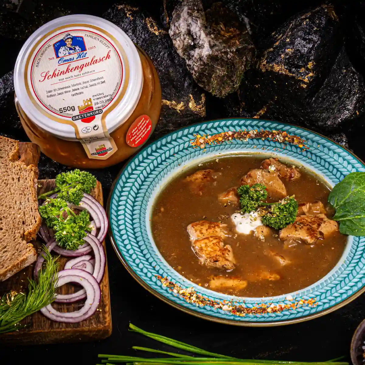 Schinkengulasch im Glas angerichet auf Teller neben Glas