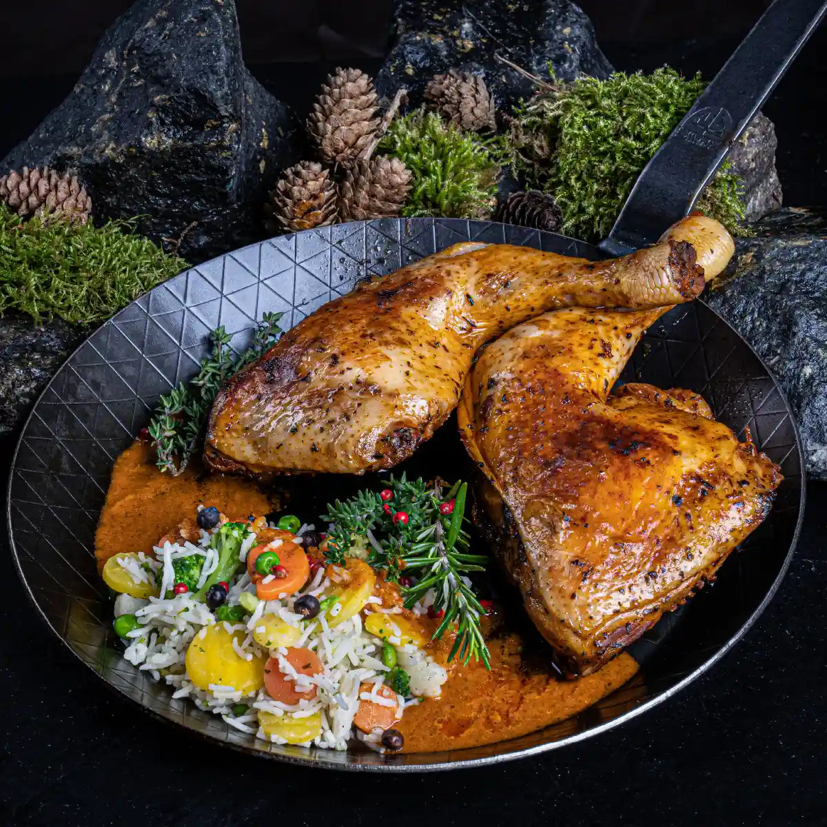 Eine Gusseiserne Pfanne mit zwei gebratenen Hähnchenschlegeln