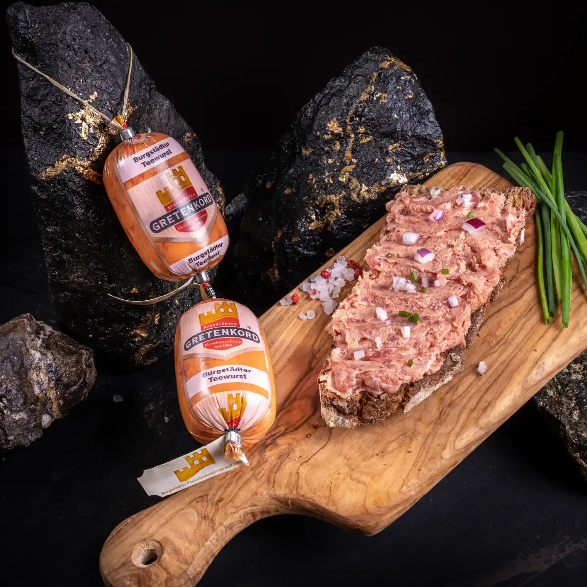 Zwei Teewurst-Stücke und daneben eine Scheibe Brot mit diesem Aufstrich