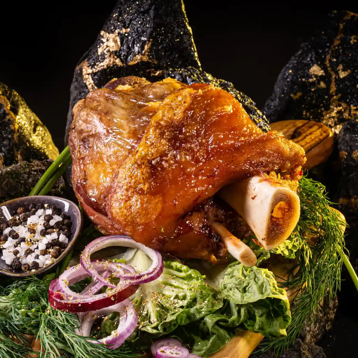 Grillhaxe auf Deko aus Salat mit roten Zwiebelringen