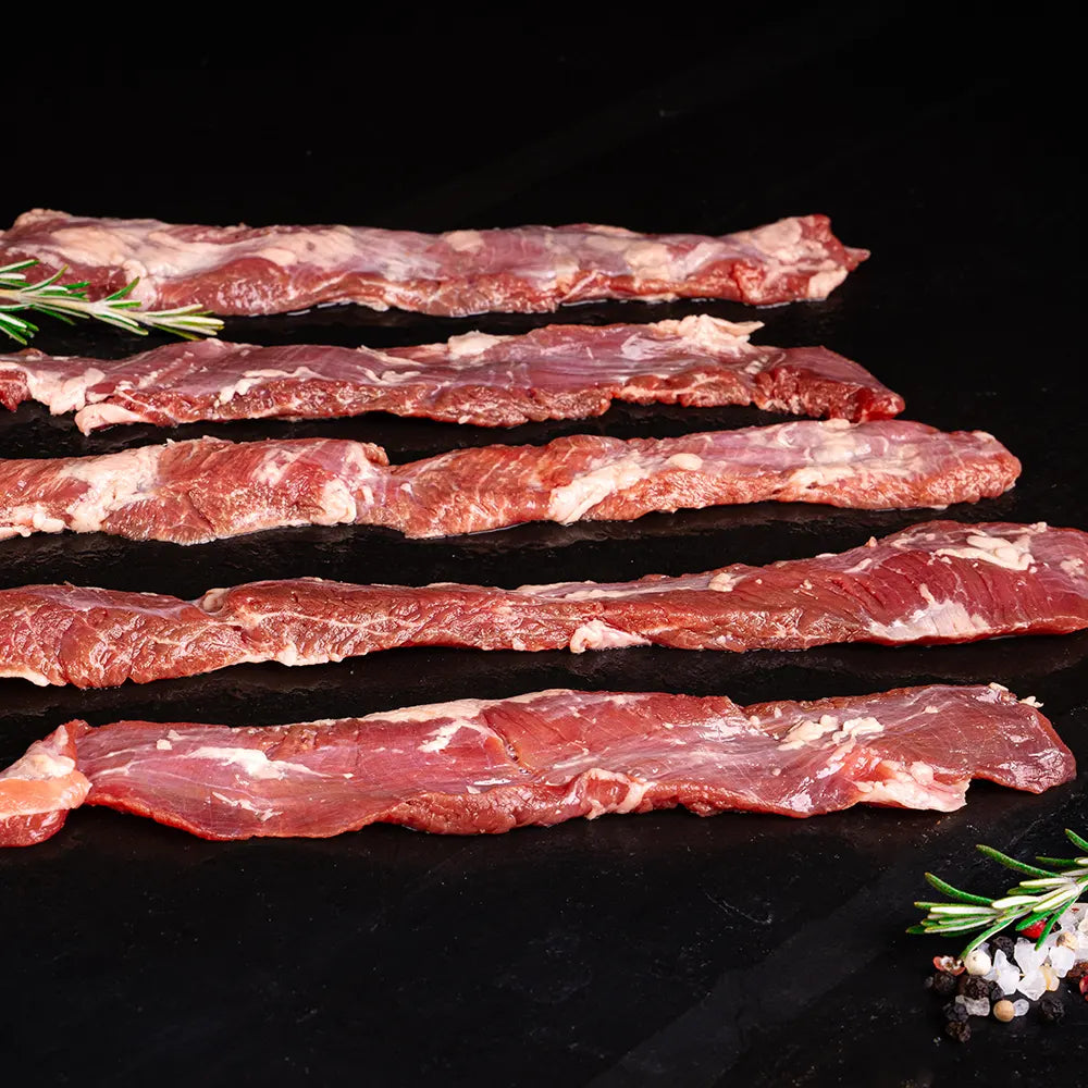 Fünf Outside Skirts vom Duroc Strohschwein von der Seite vor dunklem Hintergrund.