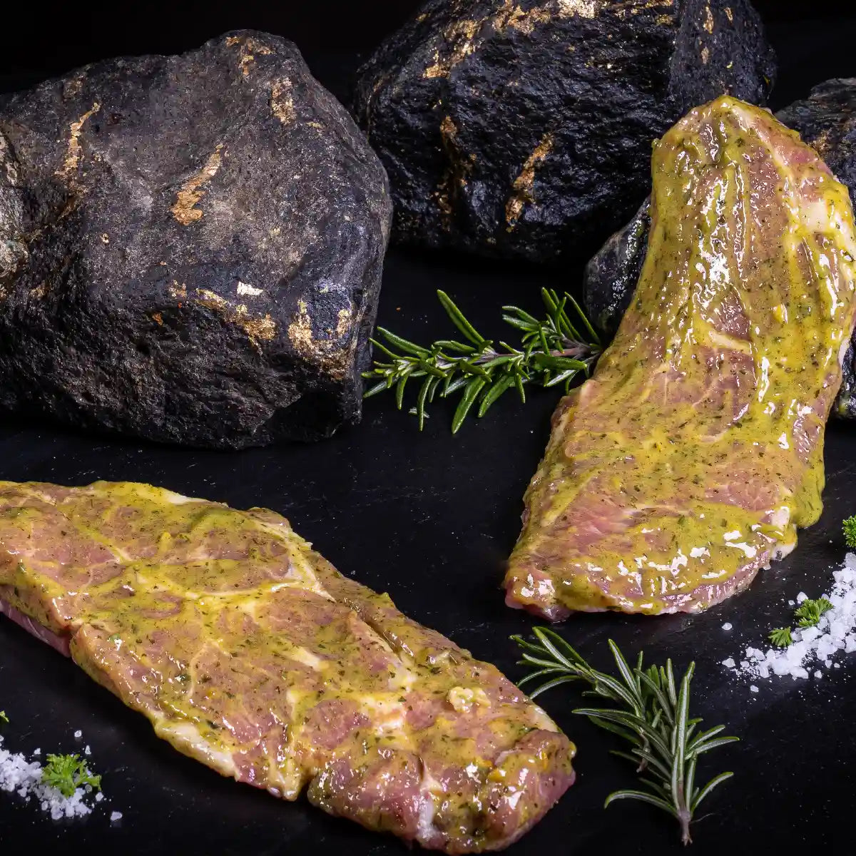 Zwei Schweinekammsteaks Knobli auf Steinen