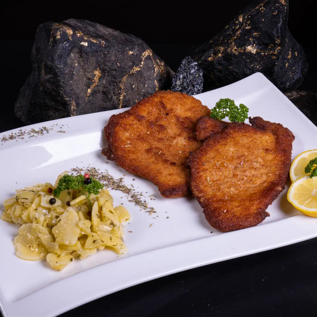 Paniertes Schweineschnitzel auf Teller mit Kartoffelsalat