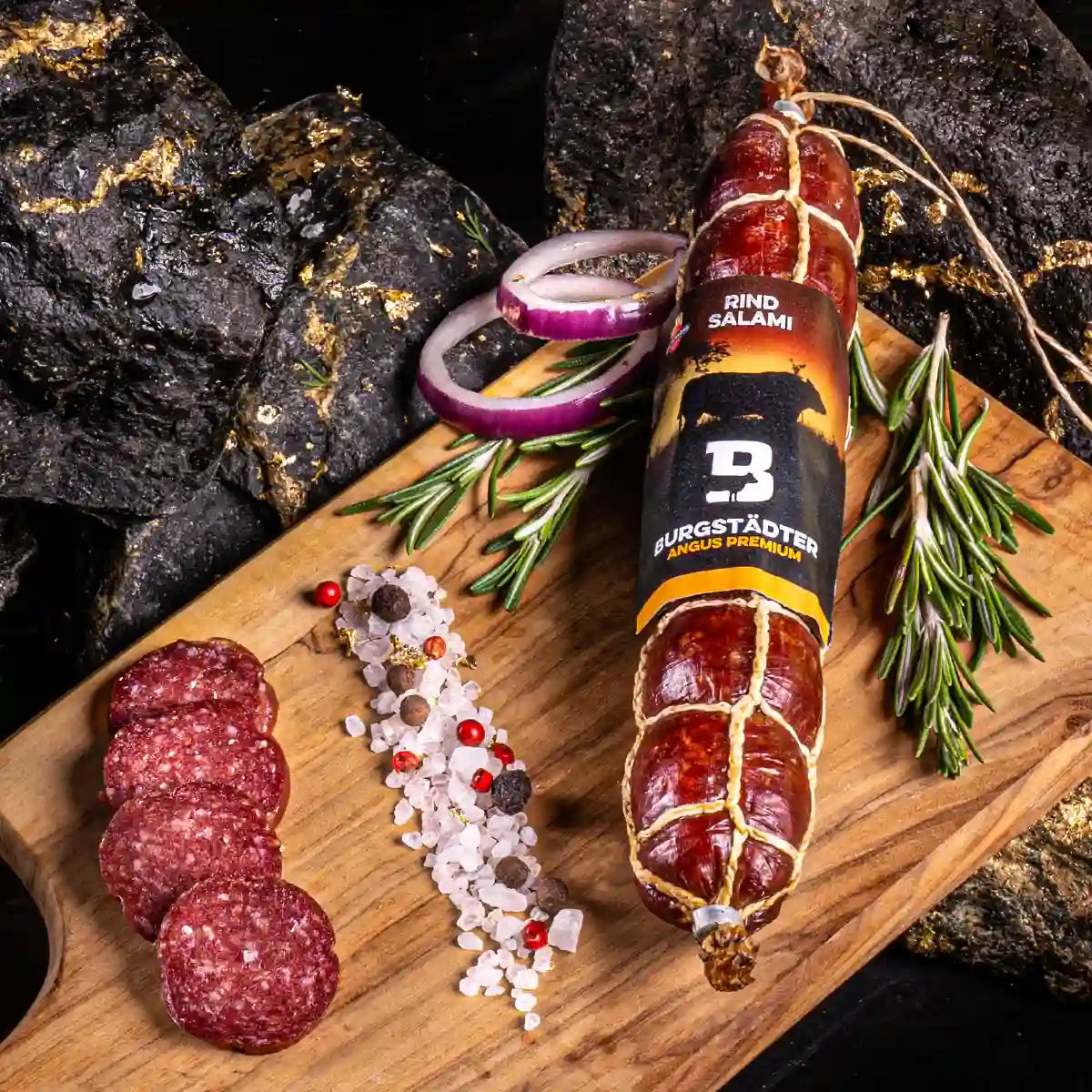 Eine Stange Angus Salami und daneben mehrere aufgeschnittene Scheiben