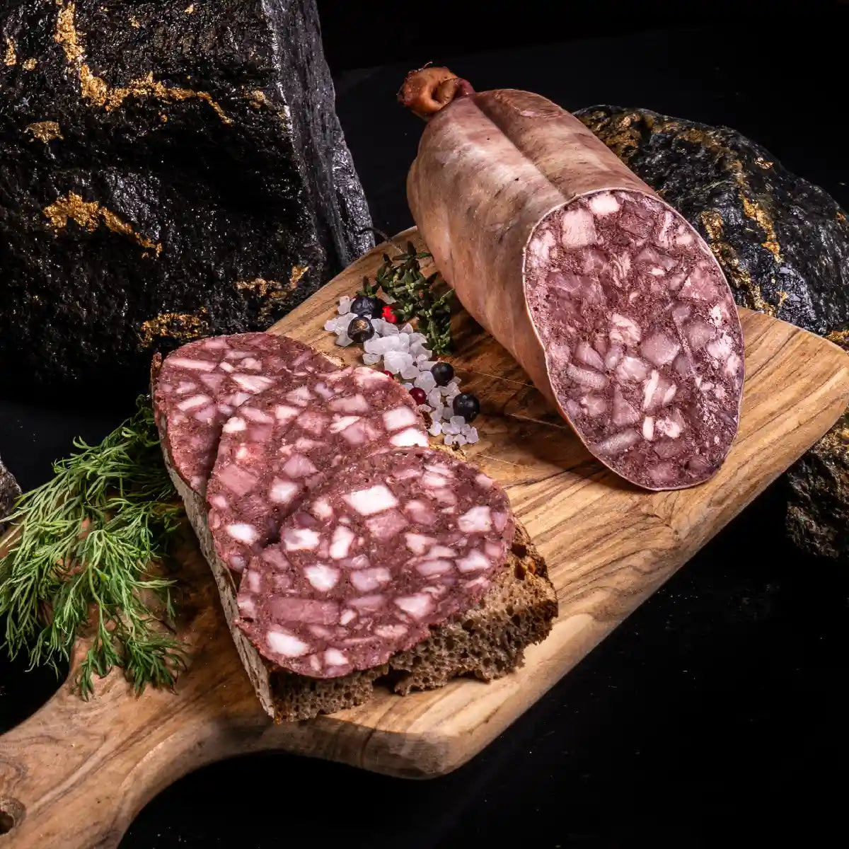 Eine angeschnittene Blutwurst und daneben mehrere Scheiben auf einem Brot