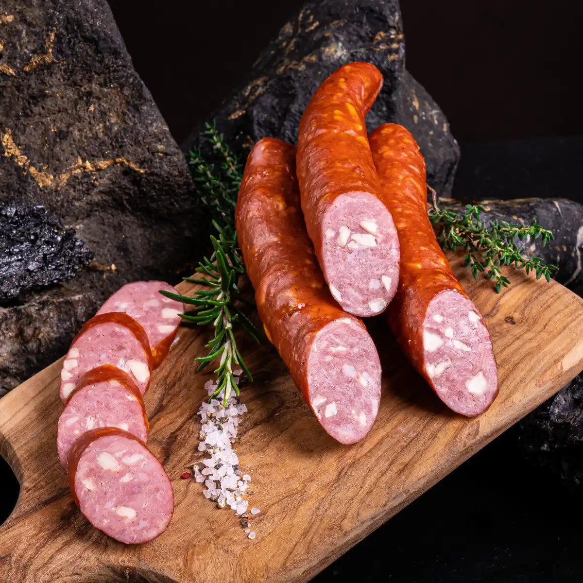 Drei Stück angeschnittene Käsekrakauer und daneben einige Scheiben