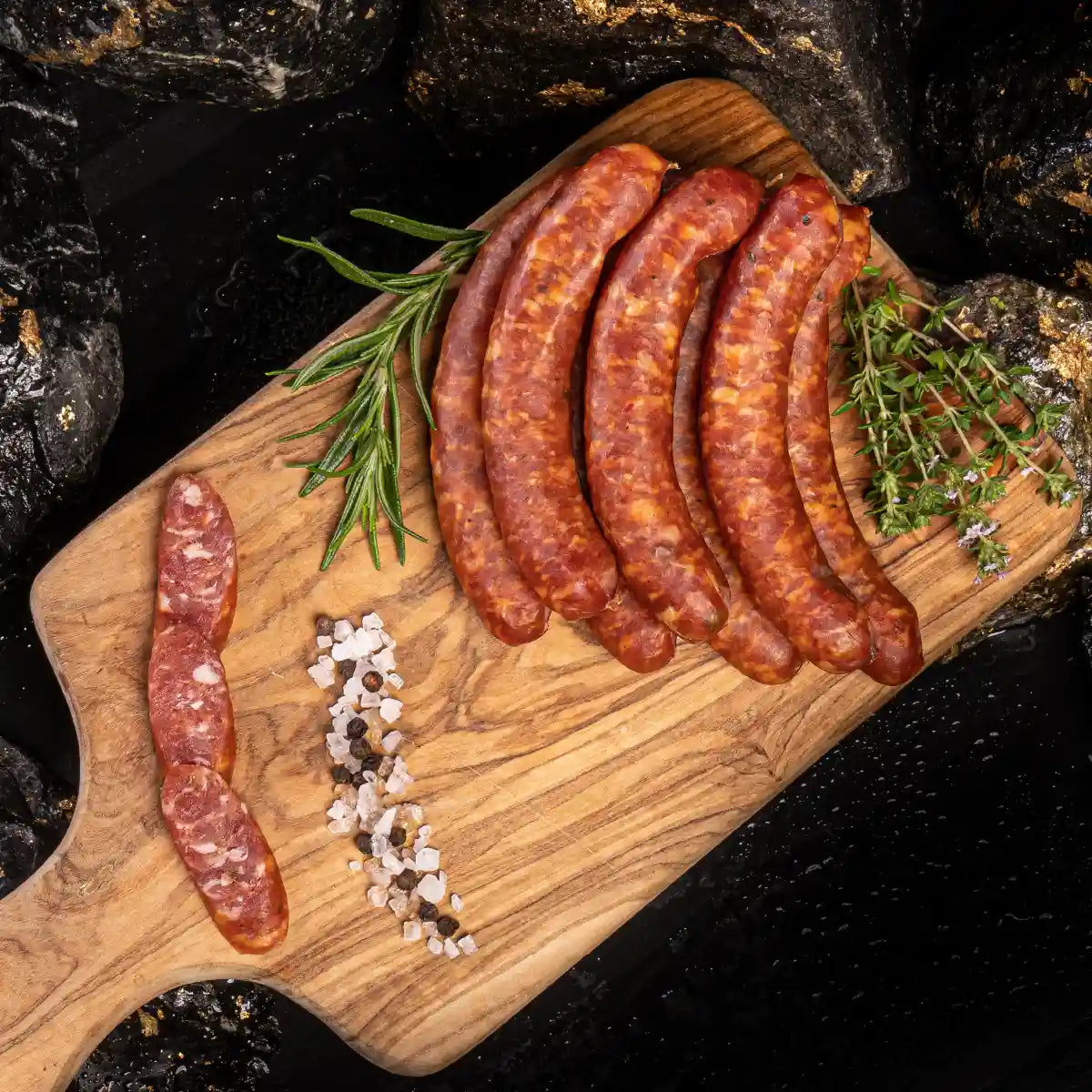 Mehrere Pfefferbeißer zusammen mit aufgeschnittenen Stücken auf einem hellen Holzbrett