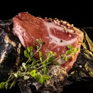 Ein Steak aus dem Kammbraten auf dunklem Untergrund