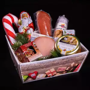 Weihnachtliche Geschenkbox mit Hackepeter im Glaus, Schokoweihnachtsmann, Zuckerstange aus Salami und weiteren Produkten