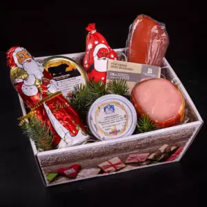 Geschenkbox aus festlich bedrucktem Karton mit Lachsschinken, Schokoladenweihnachtsmann, Gläsern mit Corned Beef und Hubertusschmalz, Salami-Weihnachtsmann