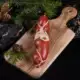 Hirschsalami von vorne schräg fotografiert auf einem Holzbrett in weihnachtlicher Dekoration mit Tannenzweigen