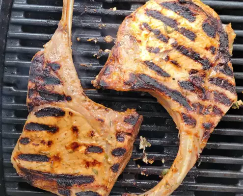 2 Tomahawk Steaks vom Duroc Strohschwein auf dem Grillrost mit Röstungsstreifen